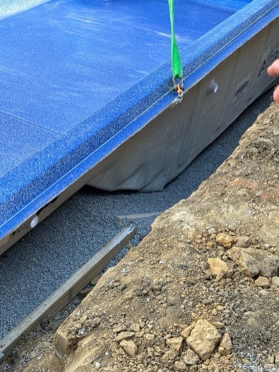 Crane setting the fiberglass shell into the ground