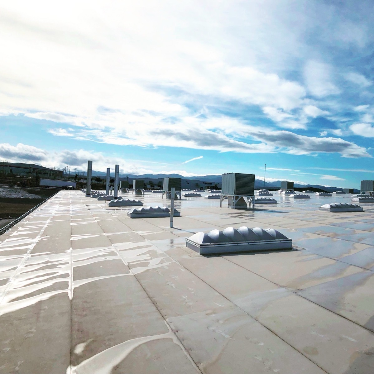 Open sky above a finished white commercial flat roof