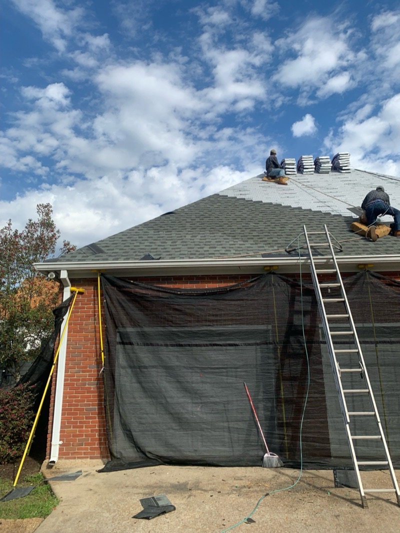 Dickerson crew shingling the roof of a brick home