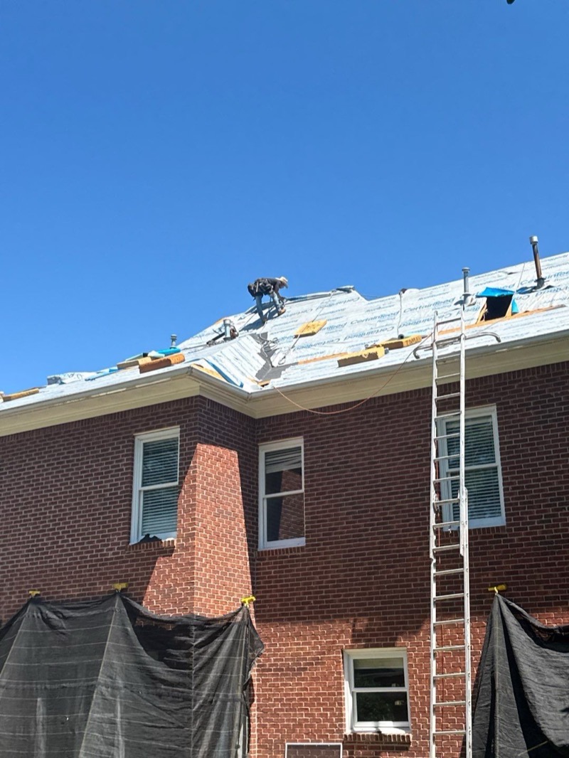 Dickerson crew member installing underlayment on a two-story brick home